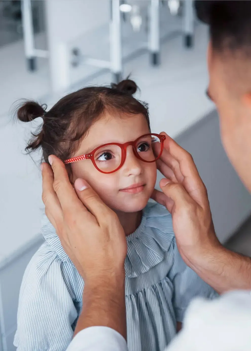 Einem Kind wird die Brille aufgesetzt