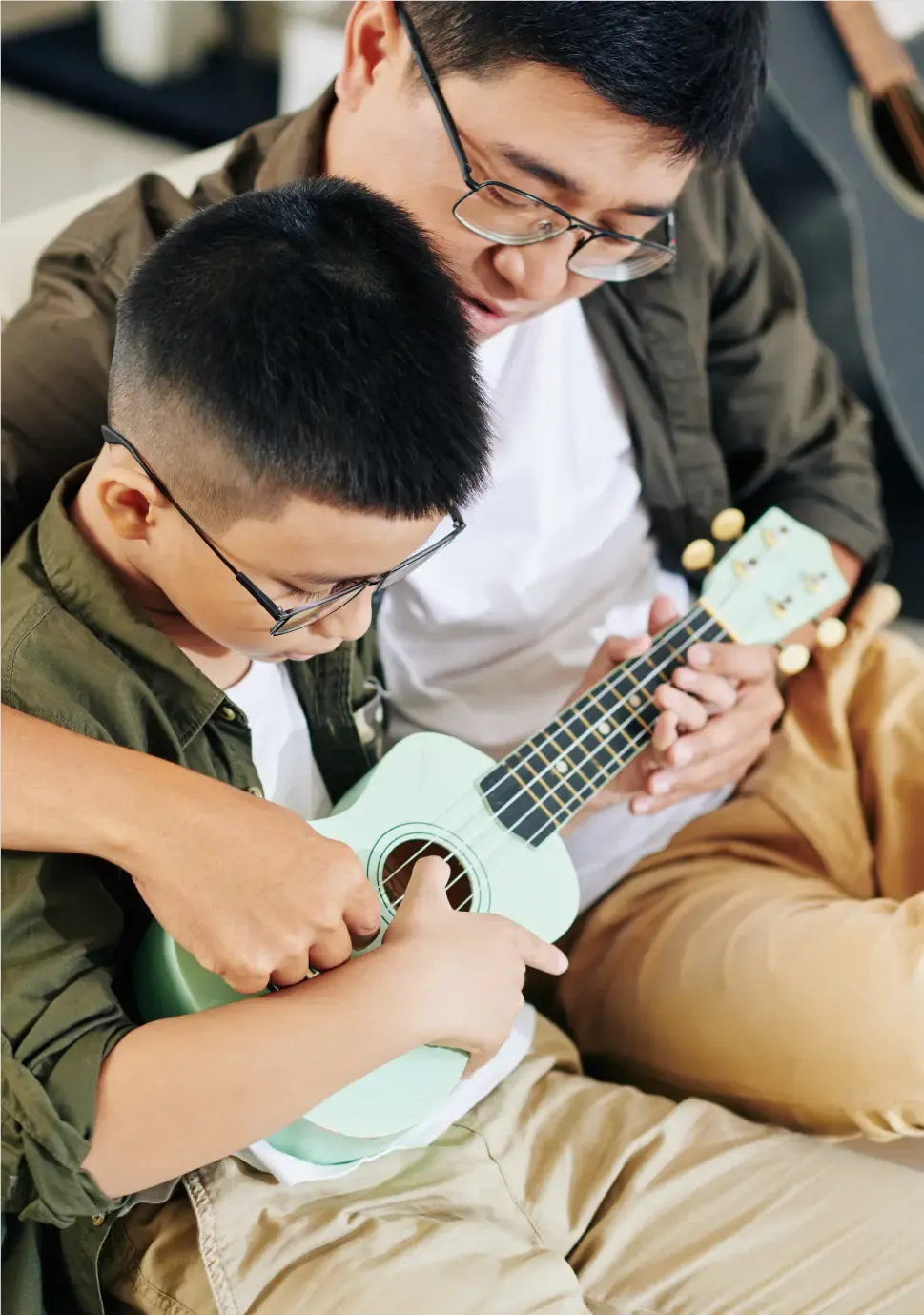 Ein Kind mit Brille spielt Ukulele