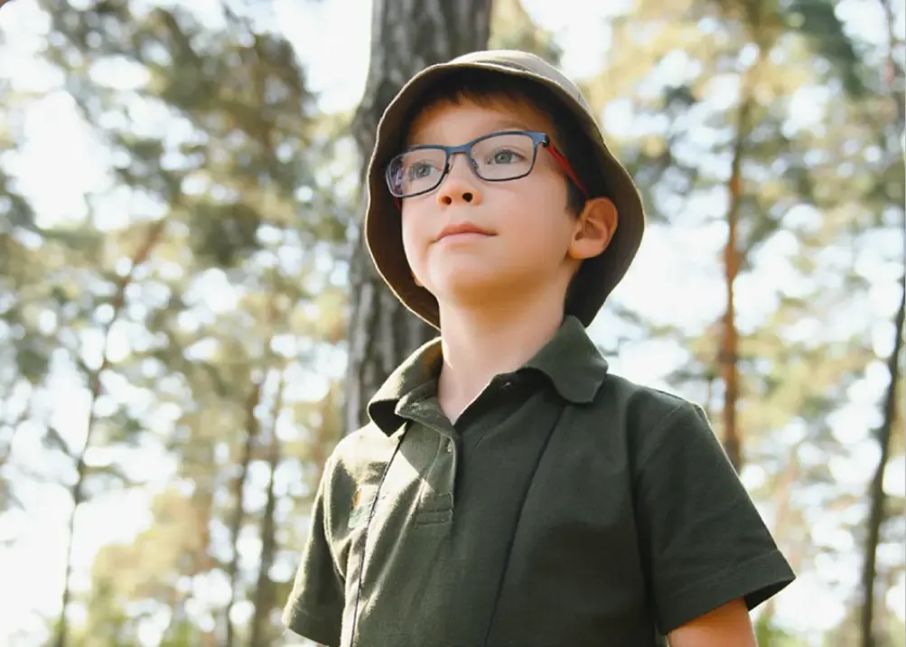 Ein Kind mit Brille im Wald