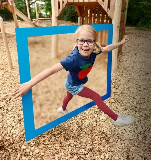 Ein Kind mit Brille springt durch ein verschwommenes Quadrat