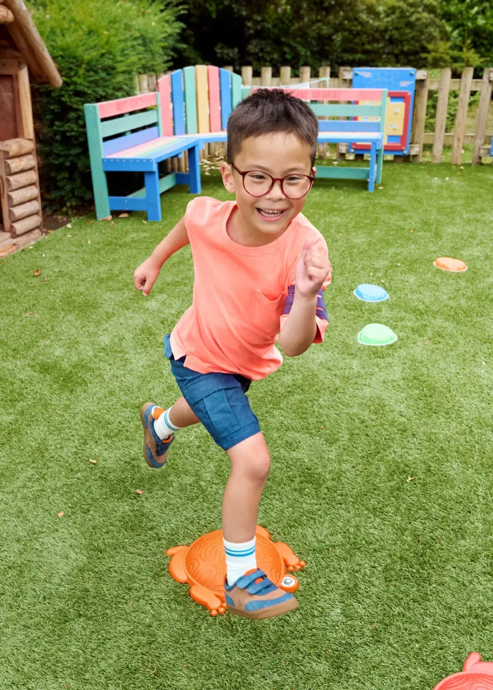 Ein Kind mit Brille, das im Garten rennt