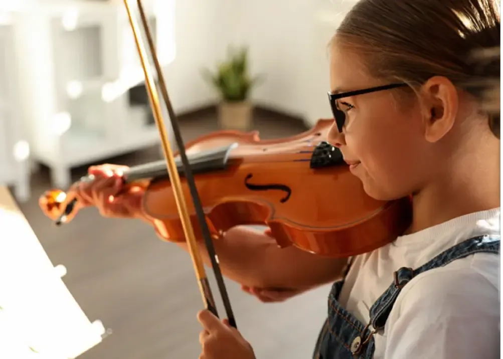 Ein Kind mit Brille, das Geige spielt